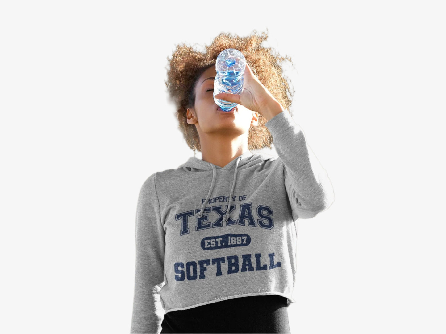 Person wearing a Gray hoodie with 'Property of Texas Softball' text drinking from a water bottle on white background.