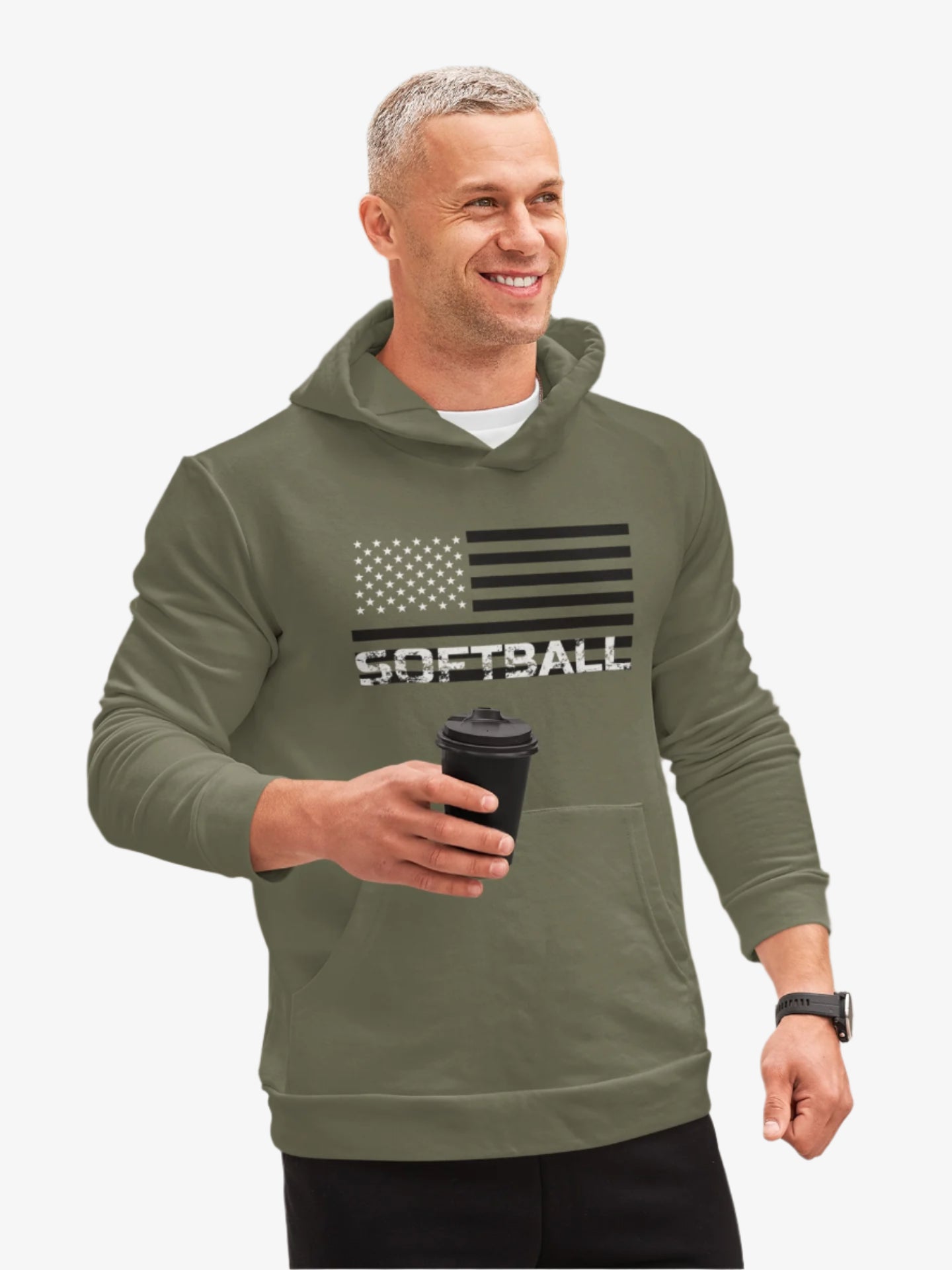 Man wearing a green hoodie with 'SOFTBALL' and an American flag design, holding a coffee cup outdoors.
